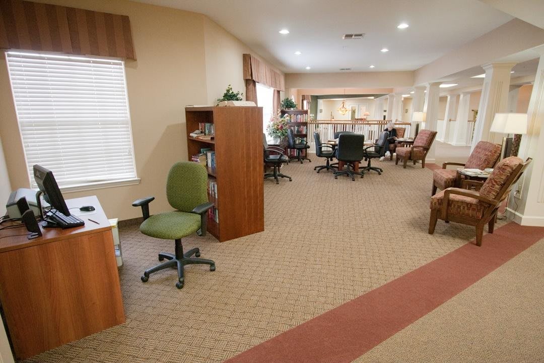 A well-furnished office space with desks, chairs, and bookshelves.