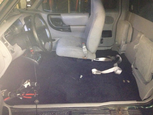 An empty driver's side view of a vehicle, showcasing the interior and floor.