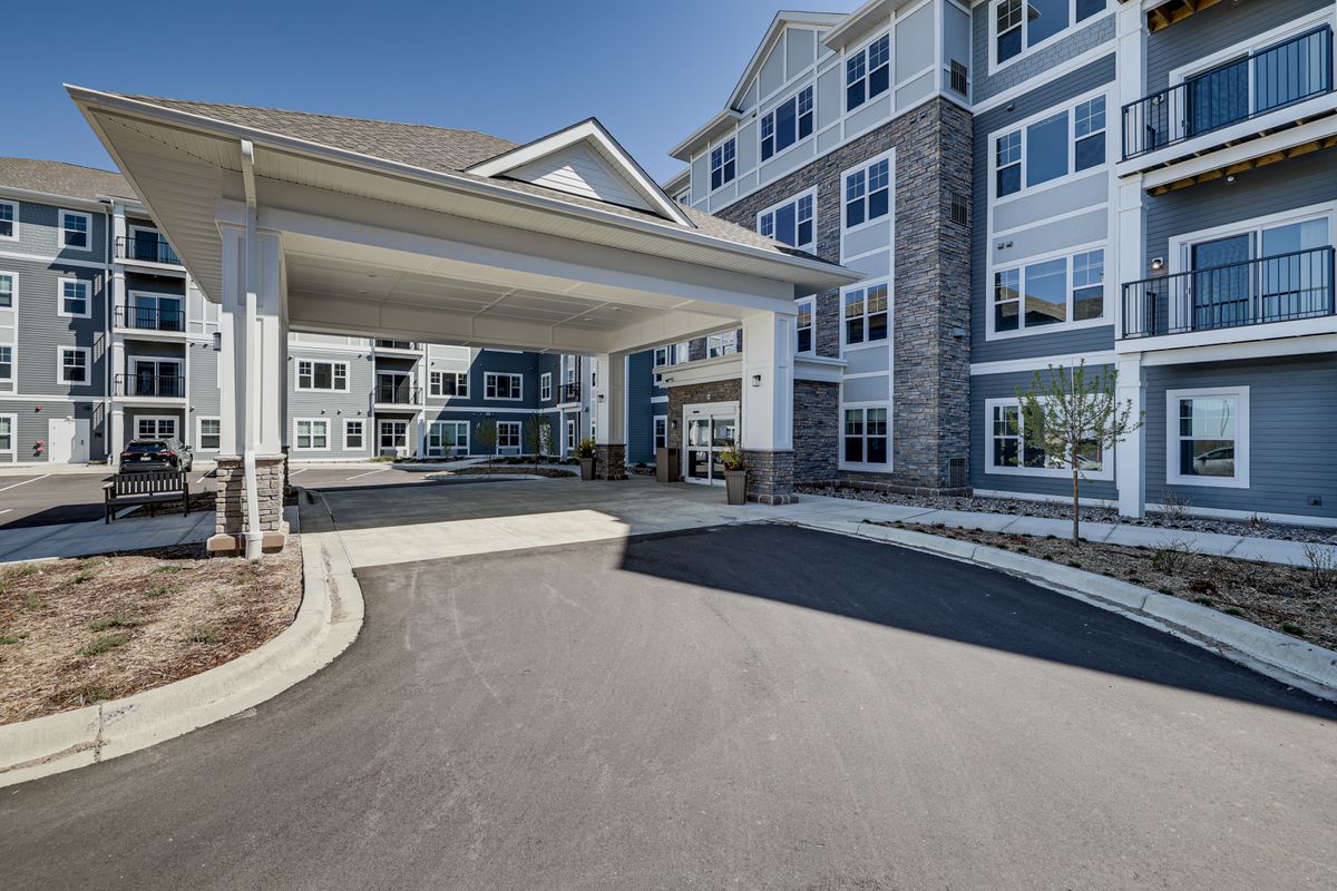 A modern building with a covered entrance and driveway.