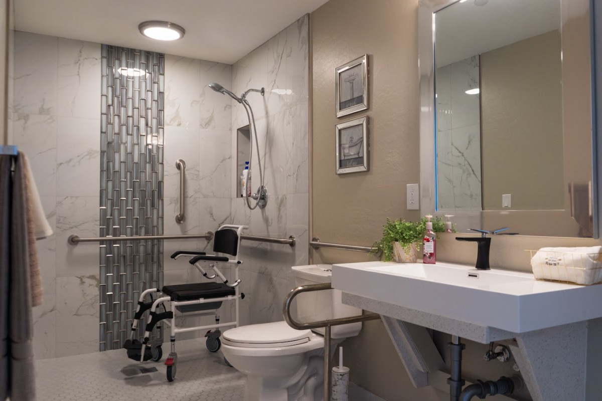A modern, accessible bathroom featuring a wheelchair-accessible shower and essential safety features.