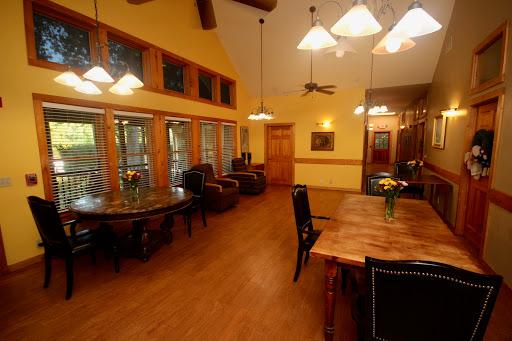 A spacious and well-lit dining area featuring wooden furniture and large windows.