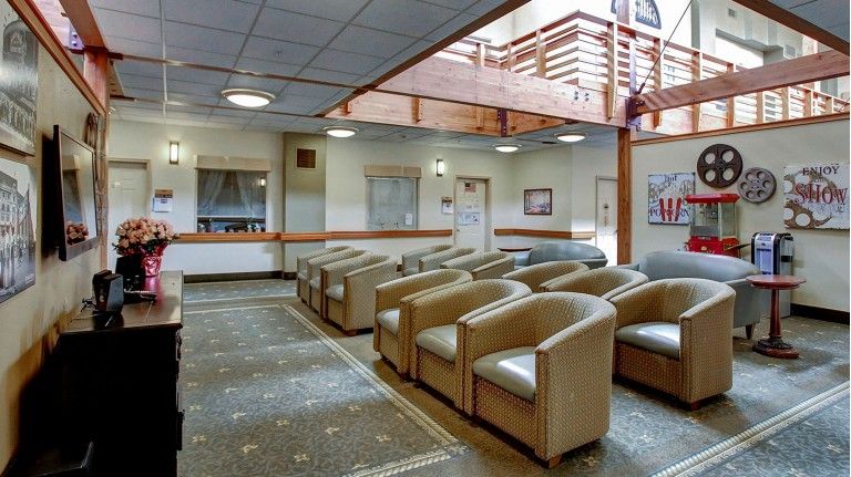 A spacious waiting room with rows of comfortable chairs and a bright, open layout.