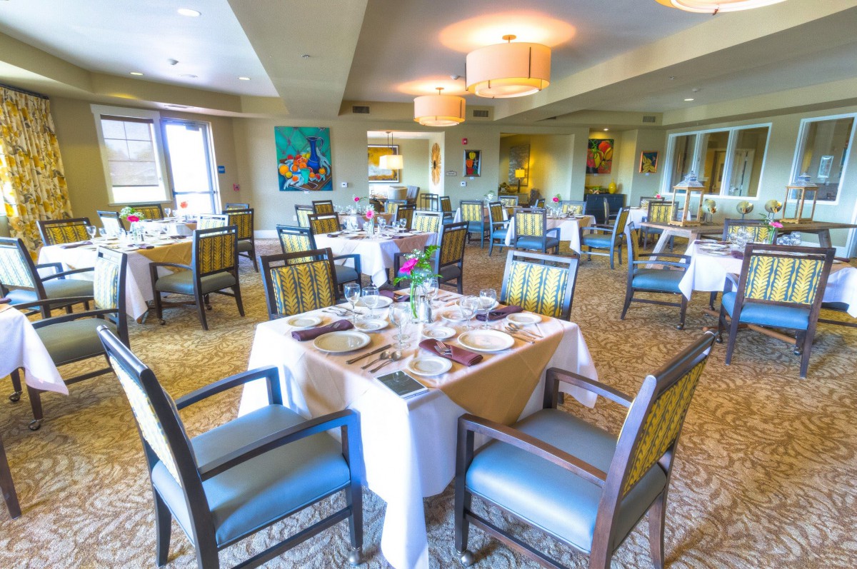 A well-arranged dining area in a restaurant with neatly set tables and chairs.