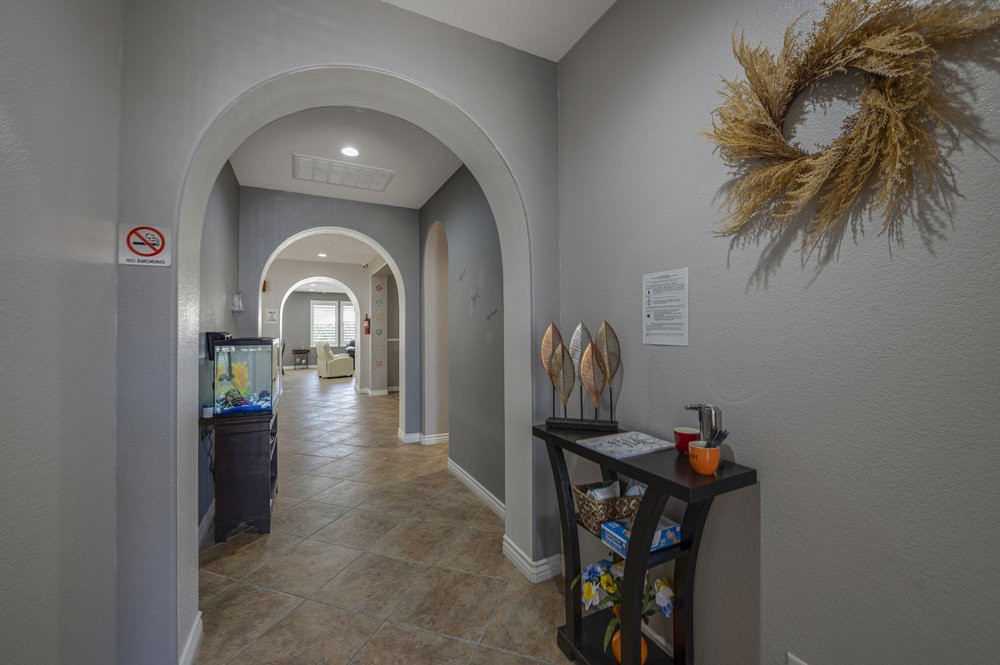 A modern hallway featuring arched doorways and neutral decor.