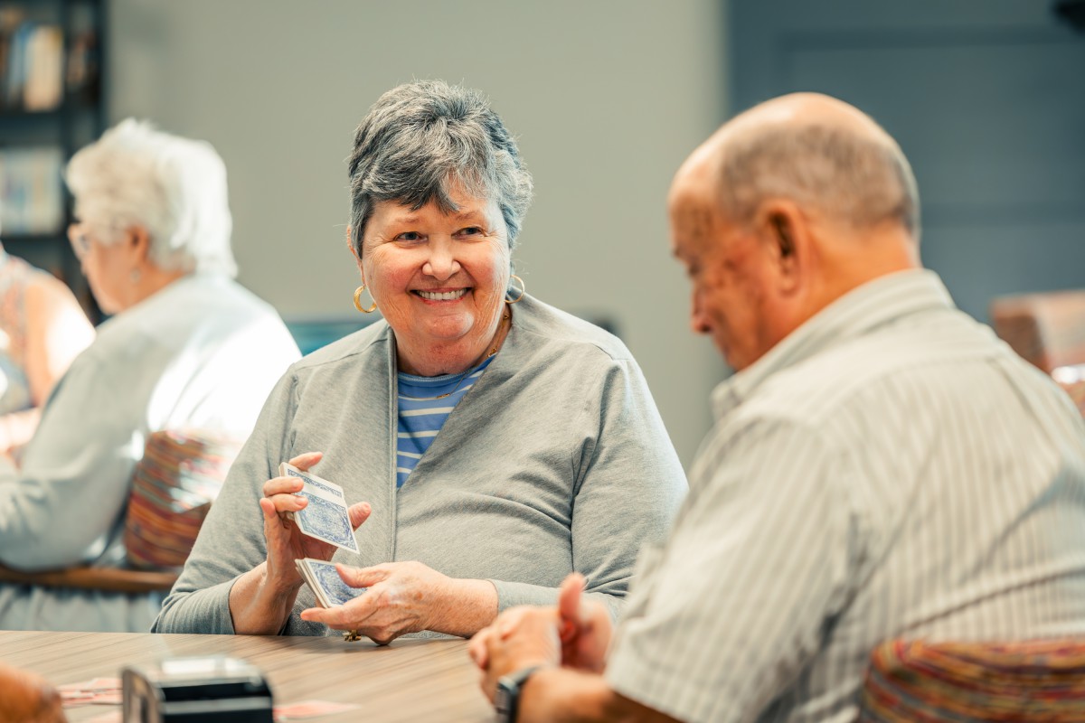 Two seniors enjoying a card game together.