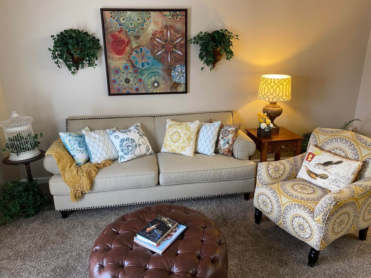 Cozy living room with a sofa, armchair, and a decorated coffee table.