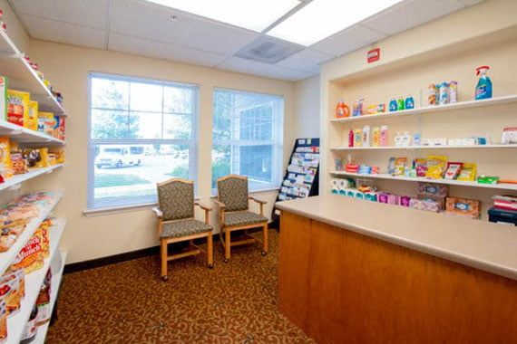 A comfortable waiting room with chairs and shelves stocked with products.