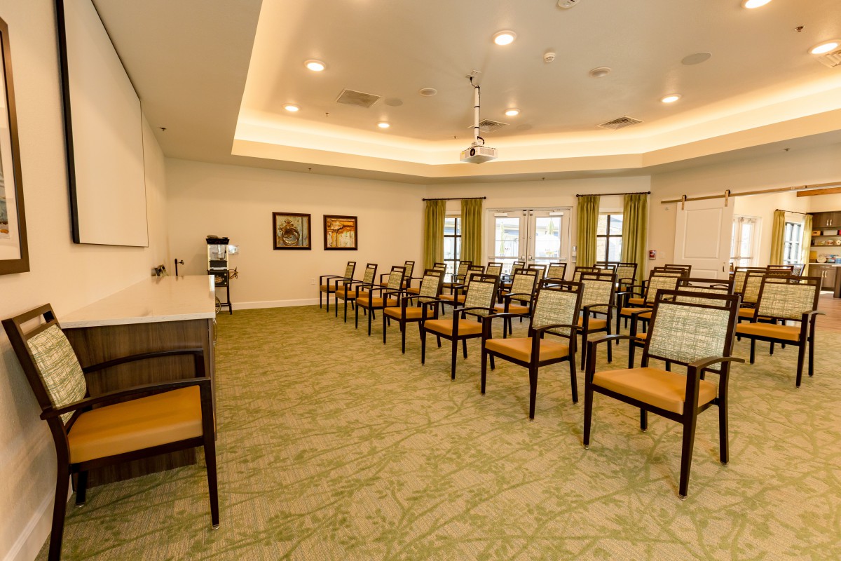 An empty meeting room with rows of chairs arranged for a presentation or conference.