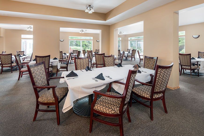 A spacious and elegant dining area with neatly arranged tables and chairs, ready for guests.