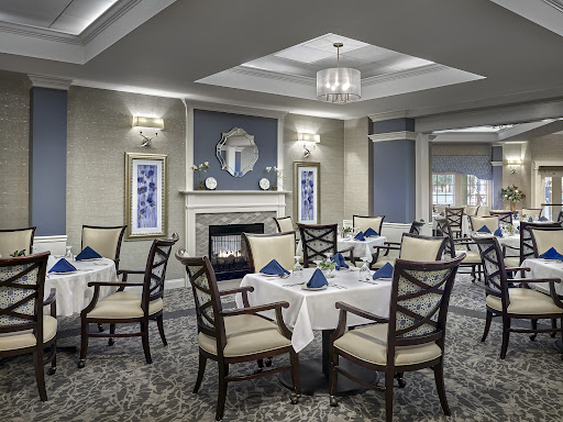 A beautifully arranged dining area featuring elegant tables and chairs, complemented by soft lighting and tasteful decor.