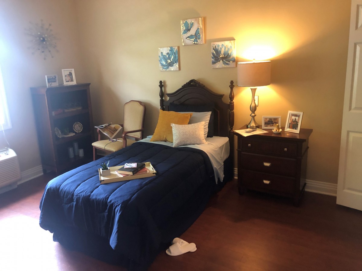 A cozy bedroom with a single bed, warm lighting, and decorative elements.