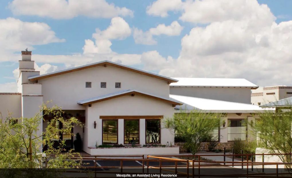 A modern residential building with a front porch and a clear sky background.