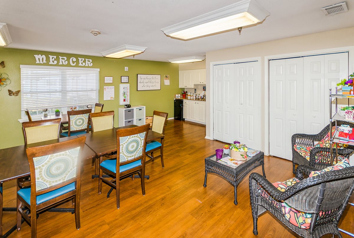 A cozy community room with tables and chairs, featuring a book-themed decor.