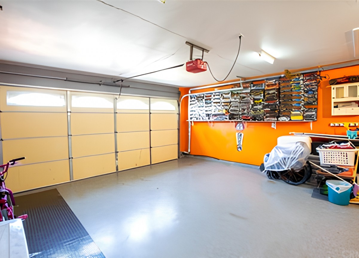 A well-organized garage with wall-mounted tools and a covered vehicle.