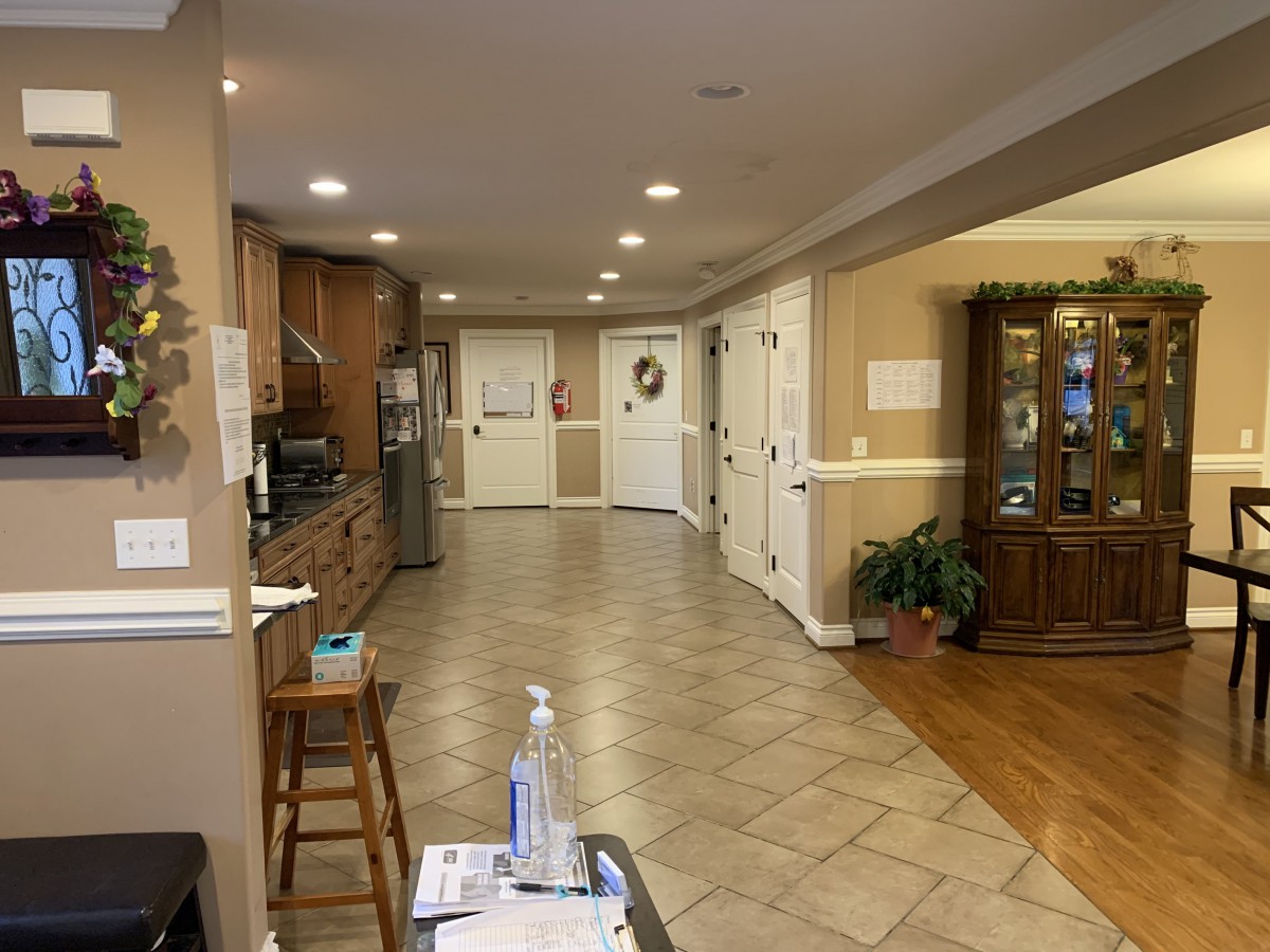 A spacious kitchen and dining area featuring a wooden cabinet, tile flooring, and modern lighting.