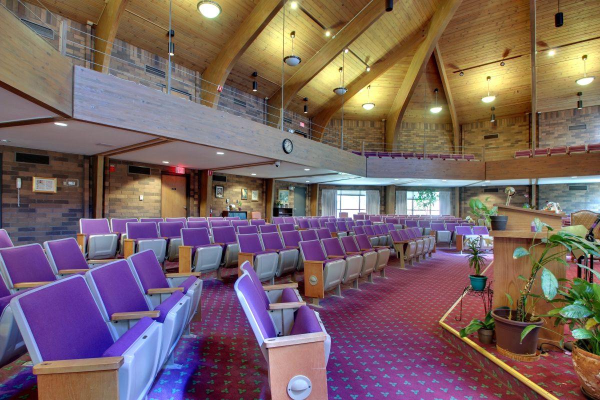 Interior view of a church featuring wooden ceilings and purple seating.