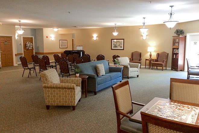 A cozy, well-furnished living room with sofas, chairs, and ambient lighting.