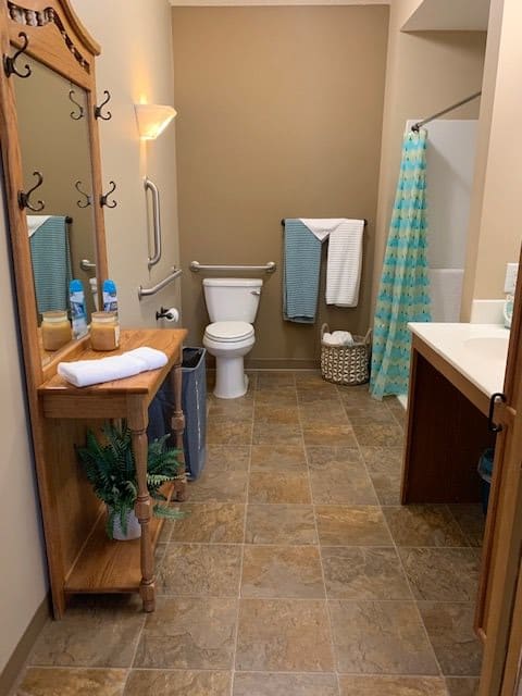 A neatly organized bathroom with a shower, toilet, and sink.
