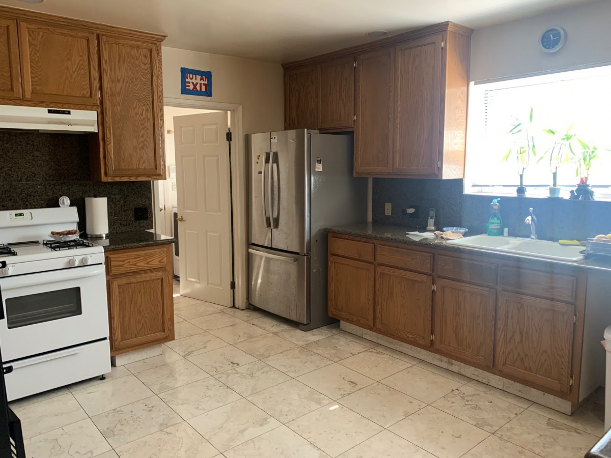 A spacious kitchen with wooden cabinets and modern appliances.