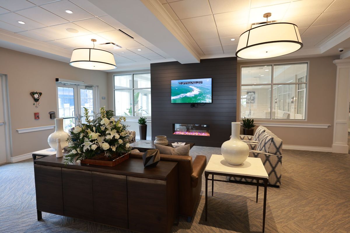 A modern living room with stylish furniture and a mounted television.