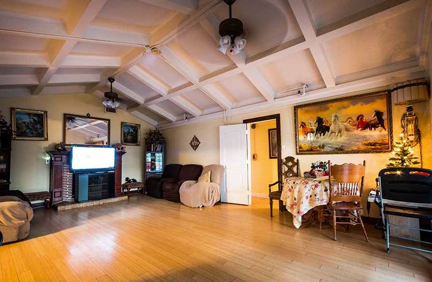 A cozy living room with comfortable furniture, a large TV, and artwork on the walls.