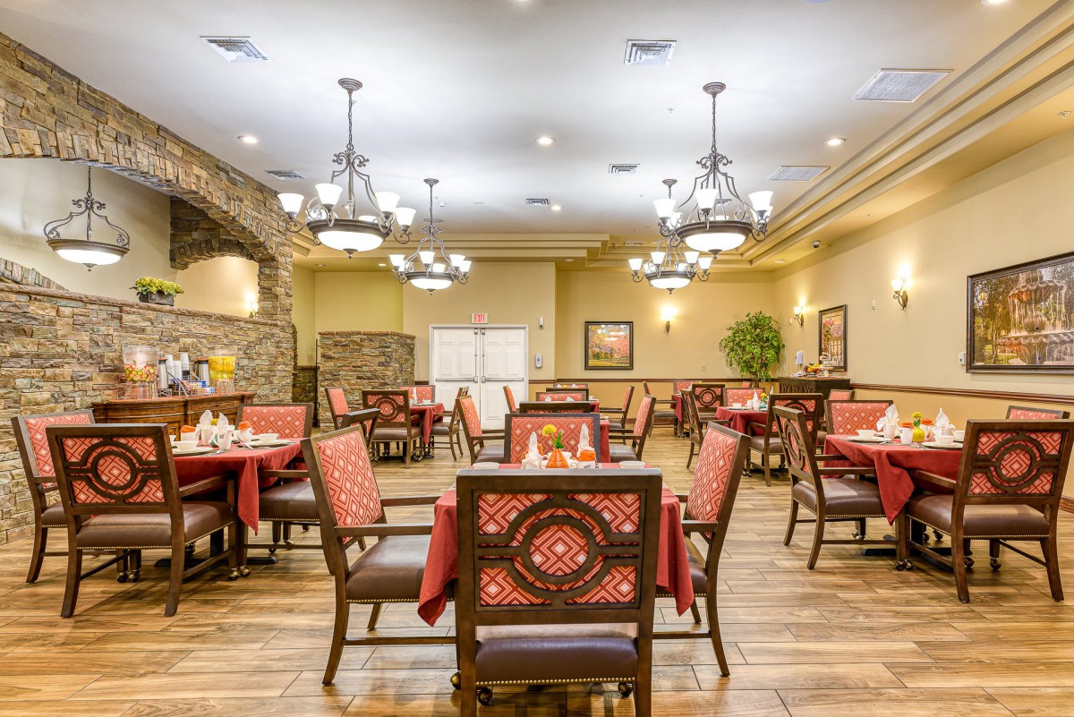 An elegant restaurant dining room with neatly arranged tables and stylish chandeliers.
