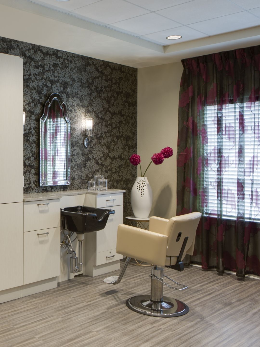 A modern hair salon interior featuring a styling chair, sink, and decorative elements.