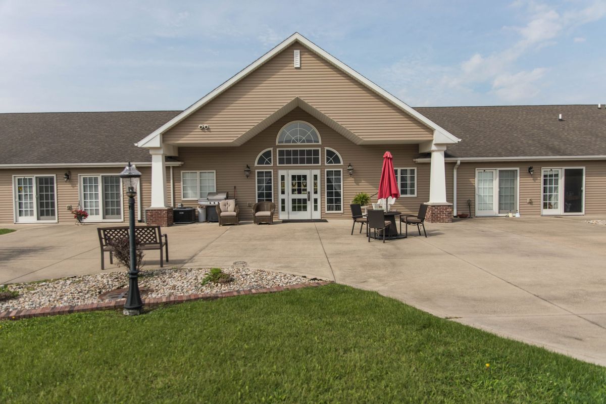A inviting residential building with a patio area and well-maintained lawn.