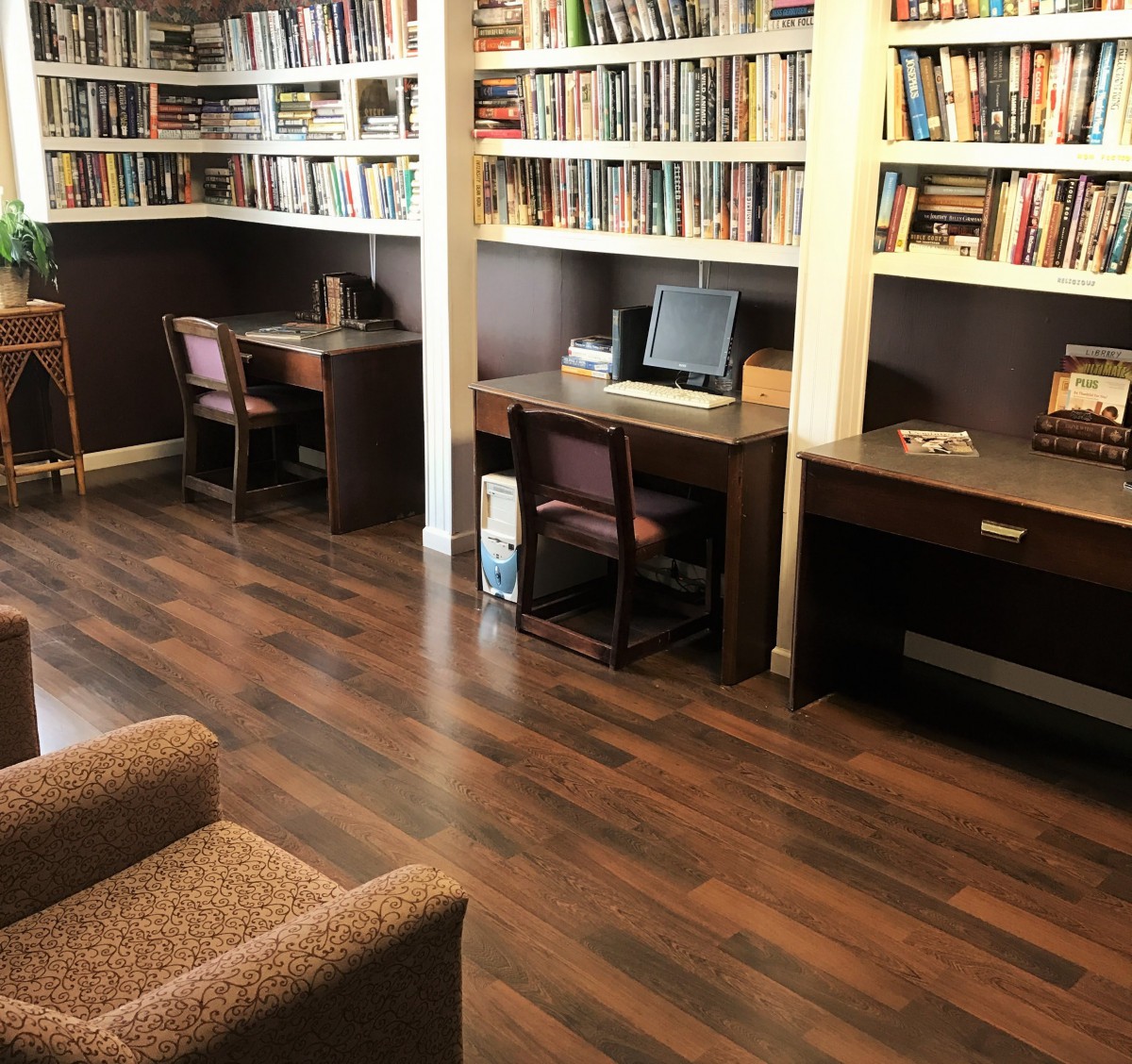 A cozy library with bookshelves, desks, and comfortable seating.