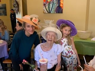 A joyful family gathering with three people wearing colorful hats.