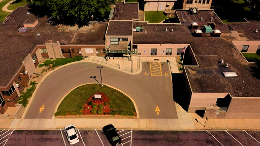 An aerial view of a building with a circular driveway and parking lot.