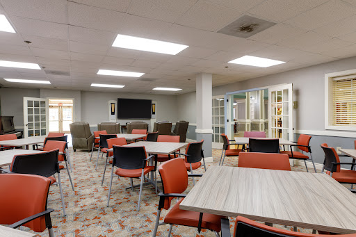 A well-lit common area featuring tables and chairs, suitable for gatherings or dining.