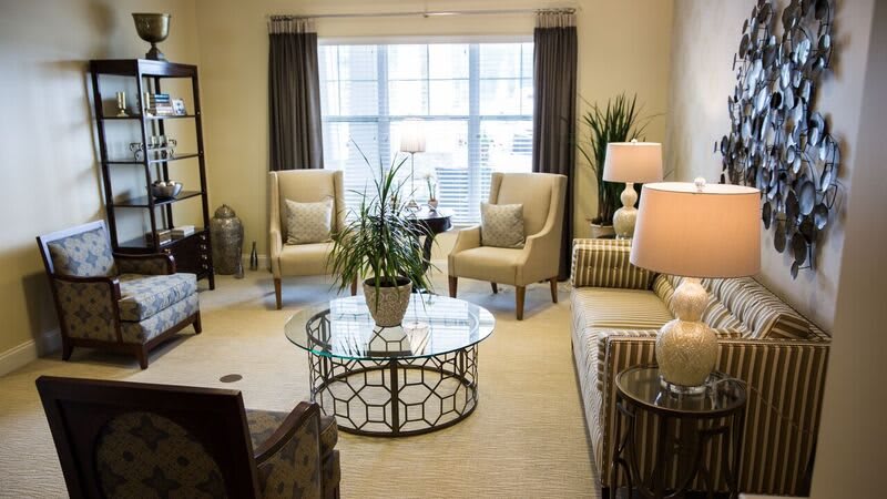 A stylish and modern living room with natural light, featuring cozy seating and elegant decor.