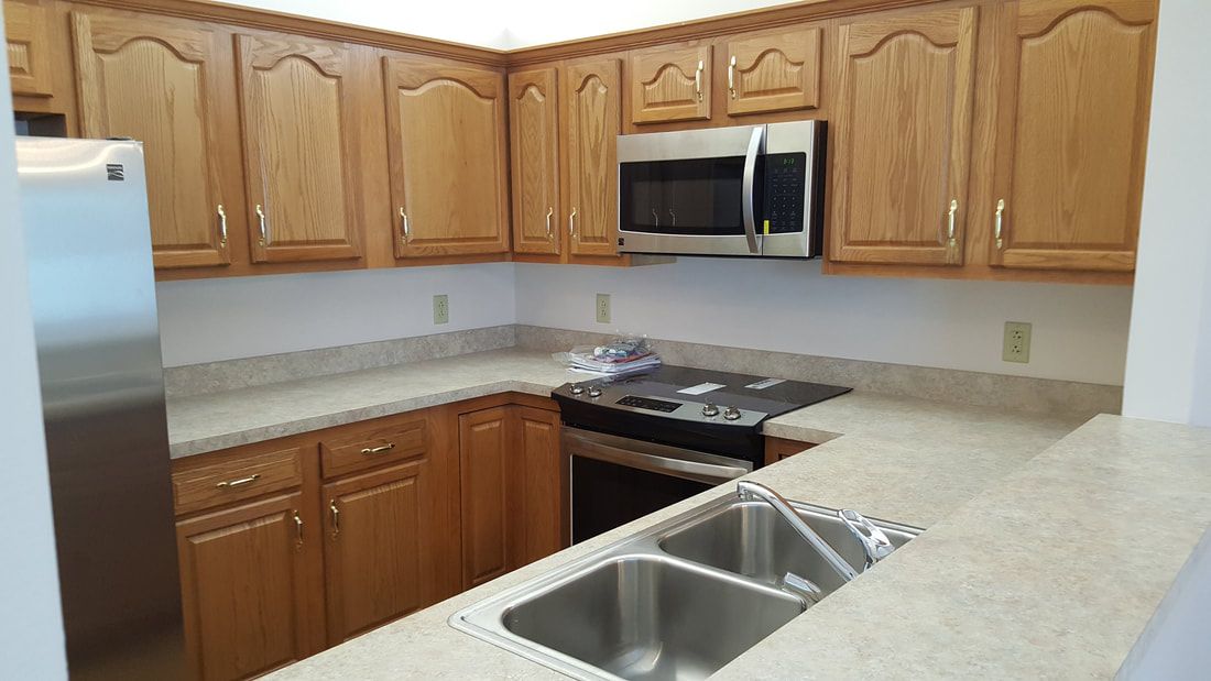 A modern kitchen with wooden cabinets and stainless steel appliances.