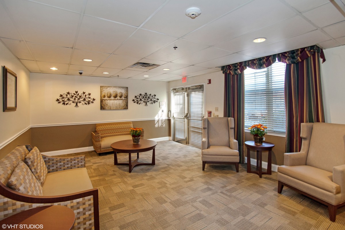 A cozy living room with comfortable seating, decorative artwork, and natural lighting.