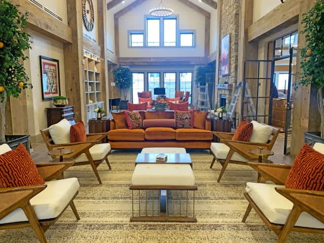 A spacious and brightly lit living room with modern furniture and a warm color palette.