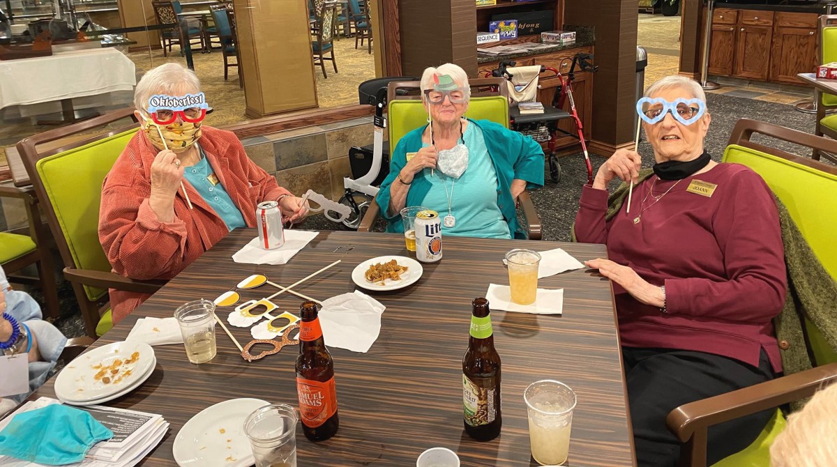 A lively gathering of seniors enjoying a fun party with drinks and masks.