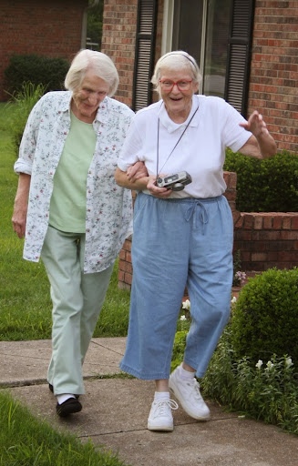 Two elderly women enjoy a walk together, sharing stories and laughter.
