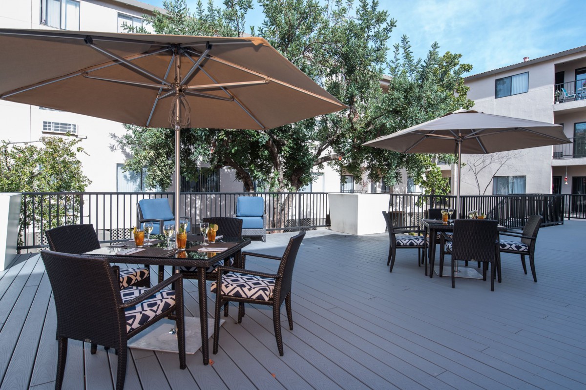 Outdoor patio area with tables, chairs, and umbrellas for relaxation.