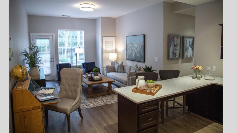 A modern and cozy open-concept living room and kitchen area with elegant furniture and decor.