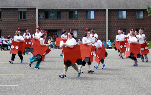 Participants in a parade dressed in creative car-themed costumes, showcasing community spirit and creativity.