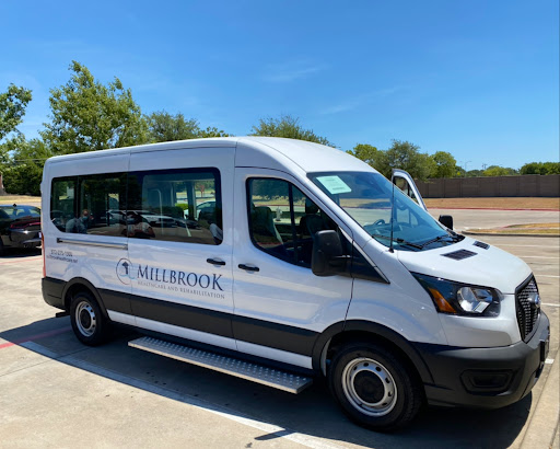 A white Ford Transit shuttle van parked in bright daylight.