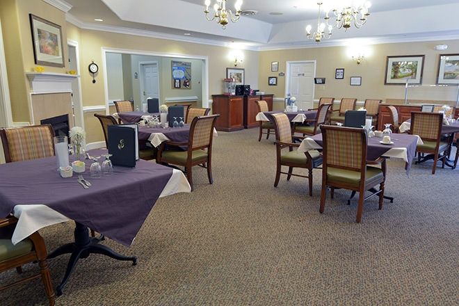 An elegantly arranged dining room with tables and chairs, set for guests.