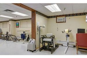 A therapy room equipped with various exercise machines and rehabilitation tools.