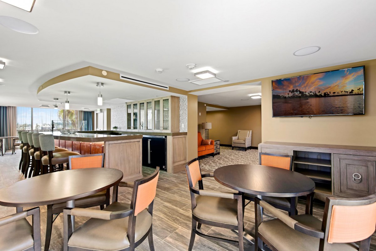 A modern dining area with tables and chairs, featuring bright lighting and contemporary decor.