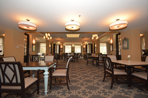 A spacious and elegantly designed dining room with stylish furniture and warm lighting.