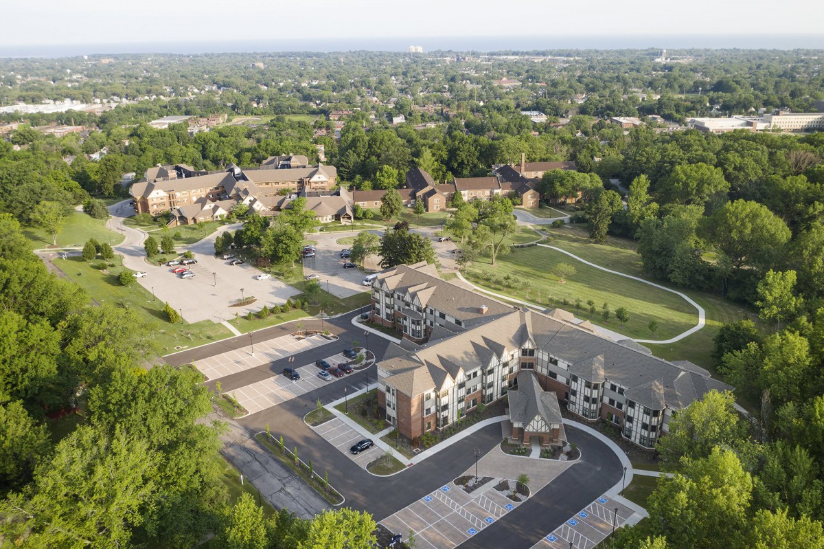 Aerial view of a residential area with surrounding greenery and roads.