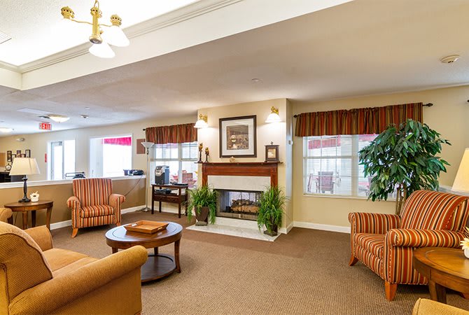 A cozy living room interior with sofas, a coffee table, and a fireplace.
