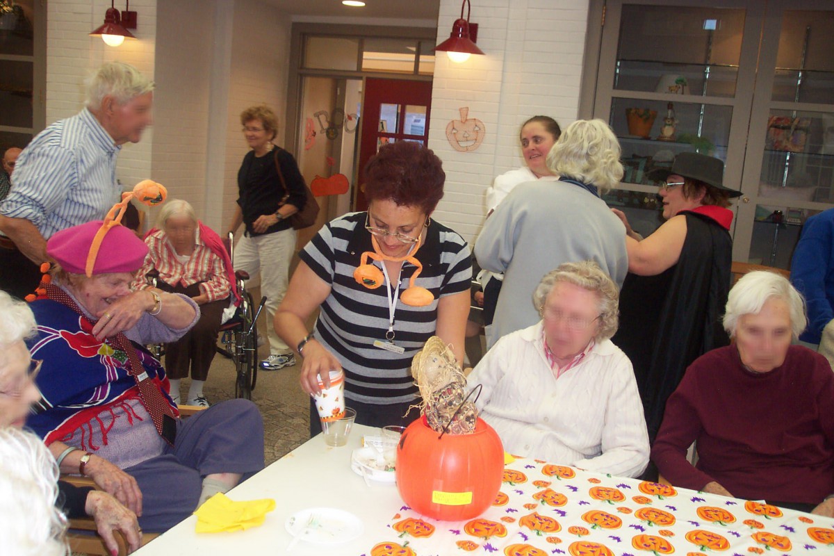 A group of people engaged in a festive Halloween activity indoors.
