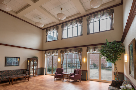 A spacious and inviting lobby area featuring large windows, comfortable seating, and a touch of greenery.